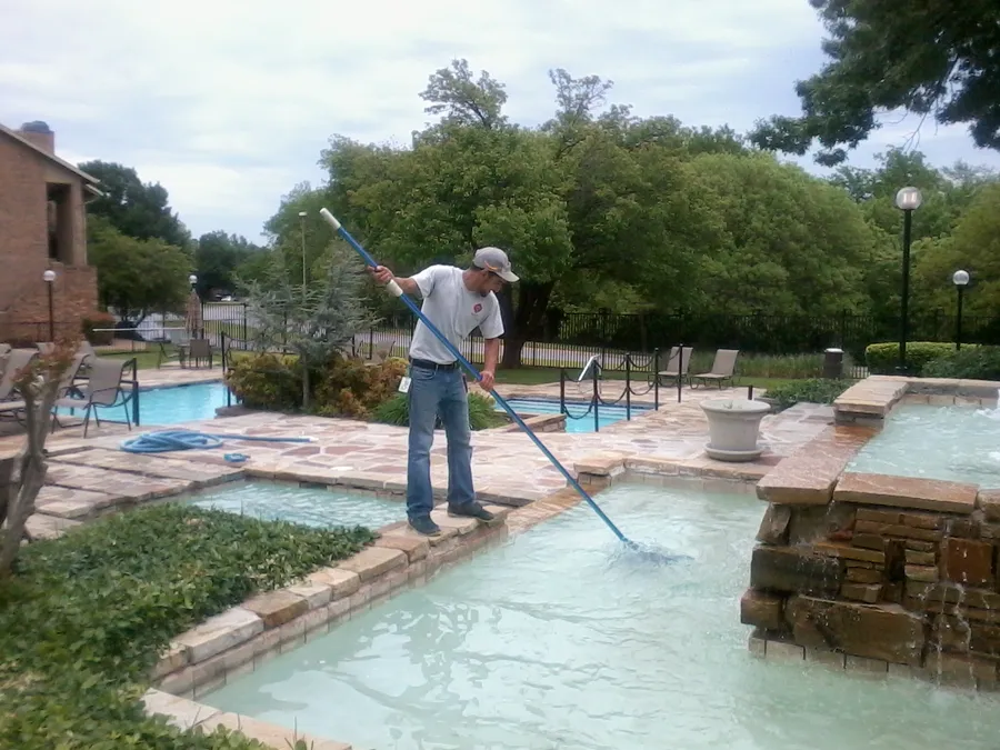 Técnico limpiando una piscina comunitaria